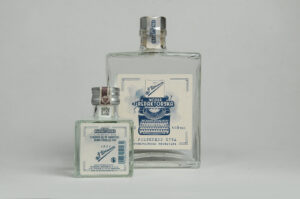 Dwie kwadratowe butelki. Mała i duża z wódką żytnią Redaktorską na białym tle.