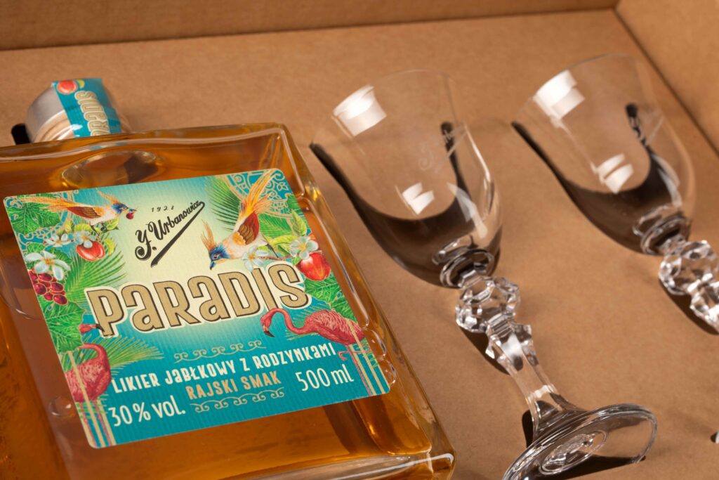 Zestaw prezentowy J. Urbanowicz Paradis 0,5 l 30% – rzemieślniczy likier jabłkowo-rodzynkowy z dwoma kieliszkami firmowymi w eleganckim boxie.